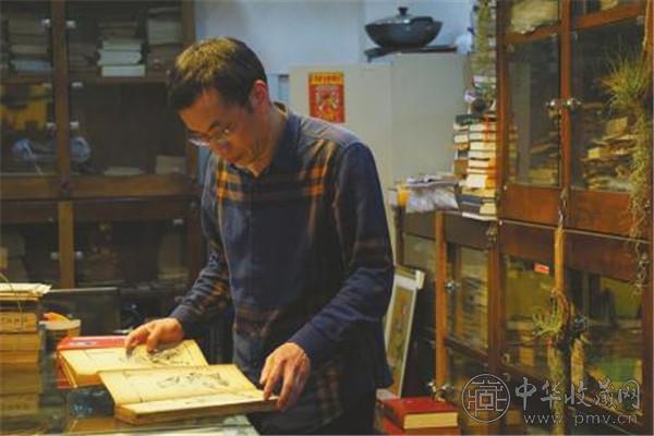 郭云龙在翻看收藏的古籍.jpg 郭云龙在翻看收藏的古籍.jpg