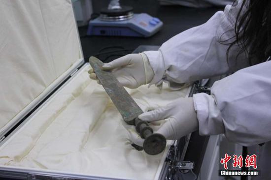修复师检查文物情况 徐雪 摄