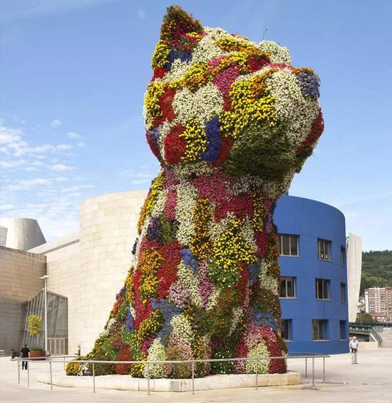 Jeff Koons在西班牙古根海姆前的作品Puppy由7万支鲜花组成，象征自信与安全感