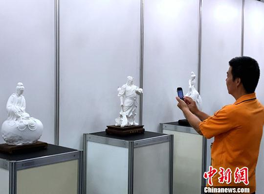 图为台湾民众参观福建陶瓷艺术大师李锦峰带来的白瓷雕塑作品。中新社记者 邢利宇 摄