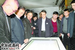 图为策展人马锋辉（左三）为嘉宾导览吴冠中手稿。