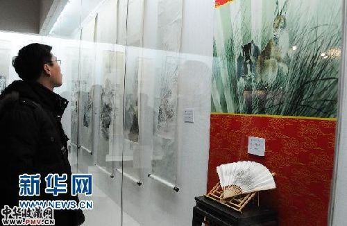 1月22日,参观者在欣赏展览。图中右侧的扇面为苏楚白所画的《双兔》成扇。