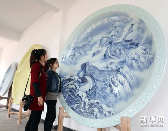 游客在观赏巨型瓷制餐具中的青花大瓷盘。