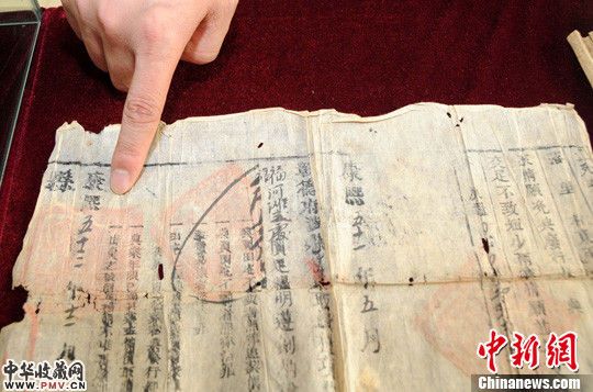 图为工作人员展示一康熙时期的老地契。中新社发 马继前 摄