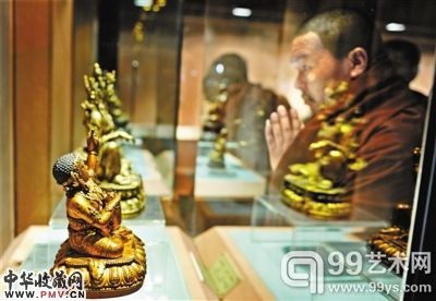 7月25日，一名僧人在观看海外回流西藏文物展上展出的精美佛像。