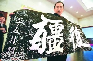 昨天，在中国人民抗日战争纪念馆，文物保管人员现场展示著名抗日将领李友邦书写的《复疆》二字拓片。本报记者 饶强摄