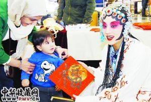 美丽的昆曲演员将书画家吴伟成现场创作的福字赠送给外国小朋友。