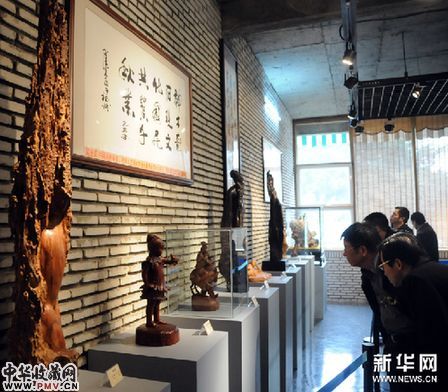 3月1日，参观者在观看木雕作品。新华网图片 沈汝发 摄