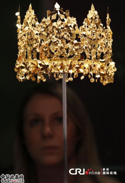 一名大英博物馆的工作人员站在一个黄金王冠的后面。该文物出土于地利亚 <div class=