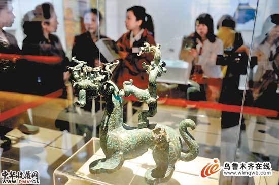 图为观众在观赏展出的文物青铜神兽。(记者 梁坤摄)