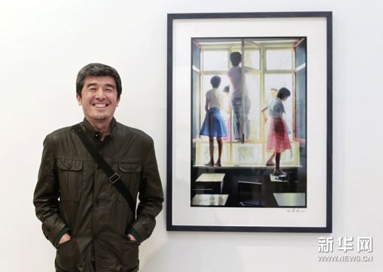 摄影家任曙林摆出他中学时的“经典姿势”站在他拍摄的作品前