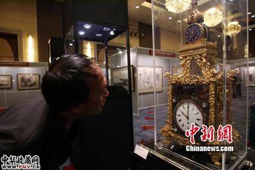 山西藏友仔细鉴赏清乾隆御制铜鎏金珐琅嵌宝大吉自鸣转花座钟，该拍品估价7000万 作 者：张云