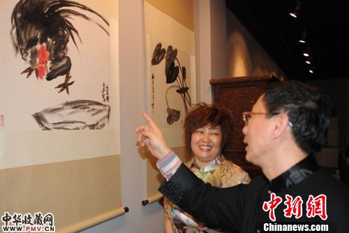 国画大师齐白石的第三代弟子画家吴悦石(右)正在为自己的学生张秋芳(左)点评展出的国画作品。