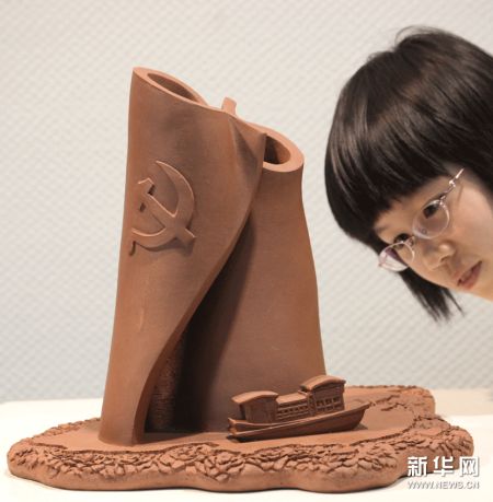 参观者在欣赏紫砂雕塑作品“红船 党旗”。