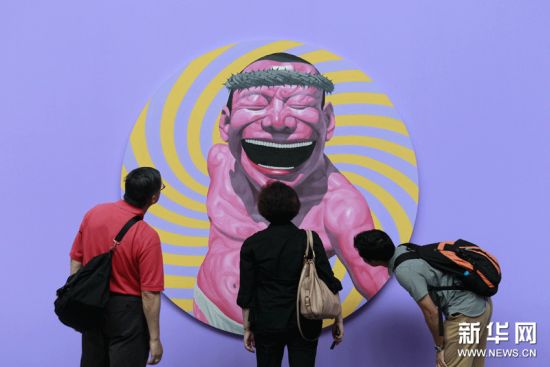 6月15日，观众在北京798艺术区佩斯北京画廊欣赏岳敏君作品。