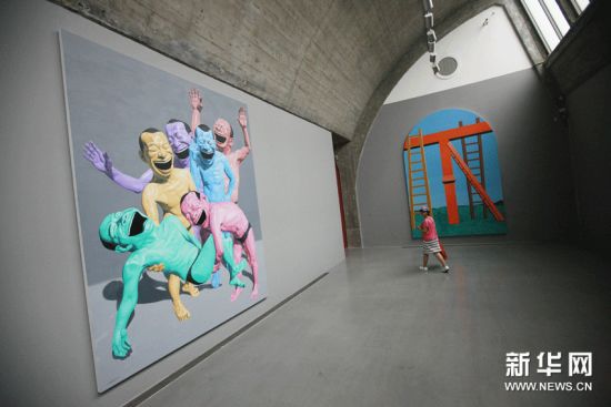 6月15日，观众在北京798艺术区佩斯北京画廊欣赏岳敏君的作品《下葬》。