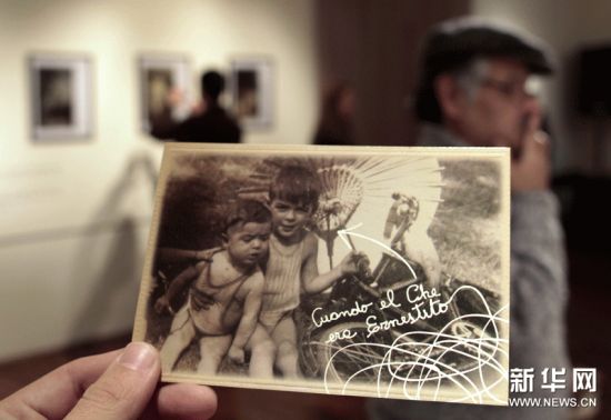 6月15日，一位参观者手拿一张反映古巴革命英雄切・格瓦拉童年生活的照片的复制品。