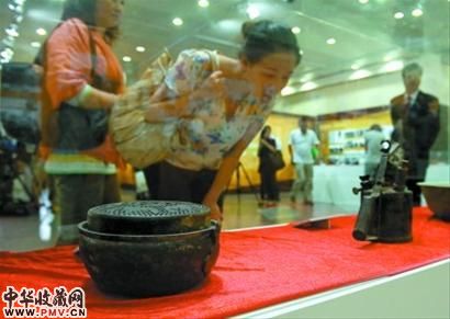 图为观众在观看展出的文物。