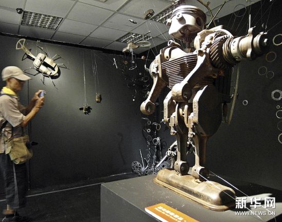 参观者在拍摄由废旧物品制作的展品