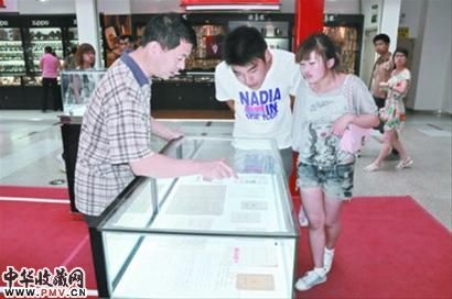 詹洪阁 (左一)向参观人员介绍展品。