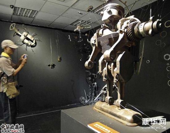 7月4日,参观者在拍摄由废旧物品制作的展品。