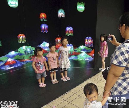 小参观者在由废旧物品制作的展品前拍照。
