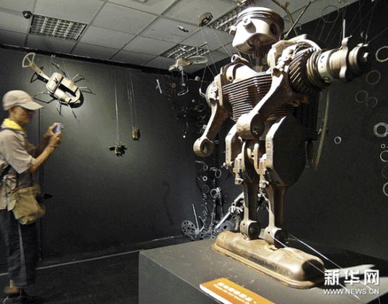 参观者在拍摄由废旧物品制作的展品。