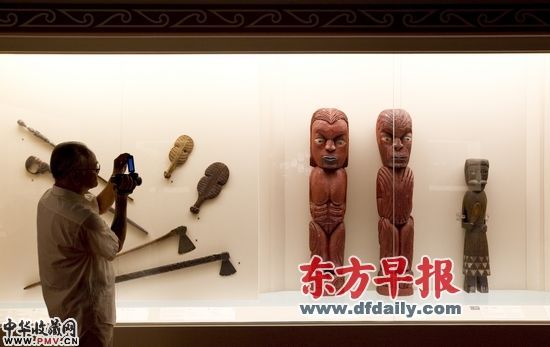 2011年7月21日,召灵仪式之后的预展上,一位参观者将镜头对准了一对毛利文身男女雕像。