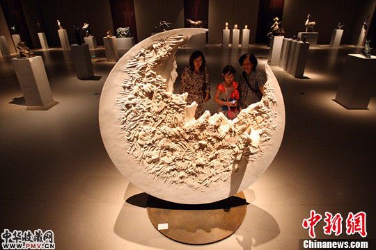 几位观众在北京中国妇女儿童博物馆观看雕塑家张崴的作品《月食》