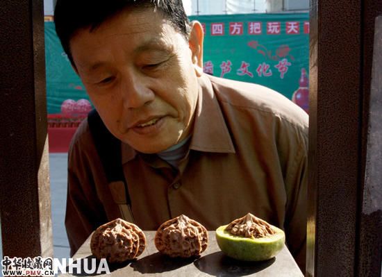 游客在认真欣赏展示的“把玩”核桃。