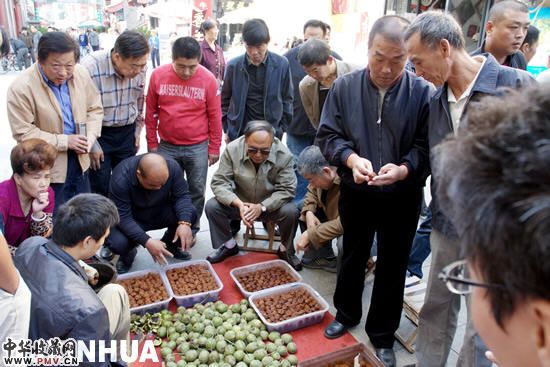 收藏、把玩爱好者在交流欣赏“把玩”核桃。