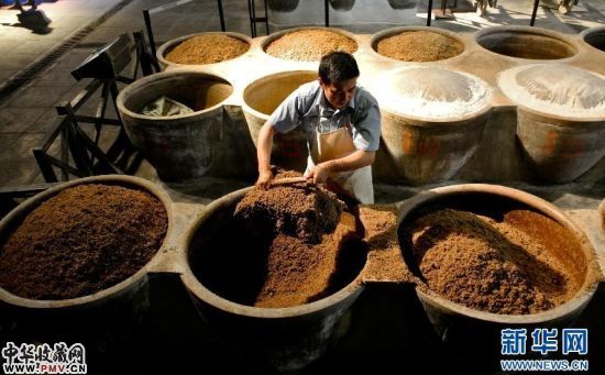 中国镇江醋文化博物馆的冯荣生师傅在进行翻醅（10月17日摄）。