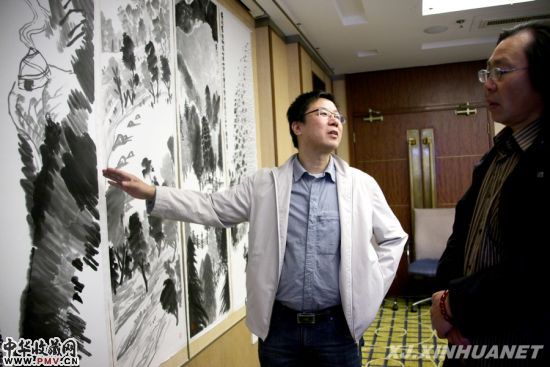 书画家徐青川（左）在向嘉宾介绍自己的作品。