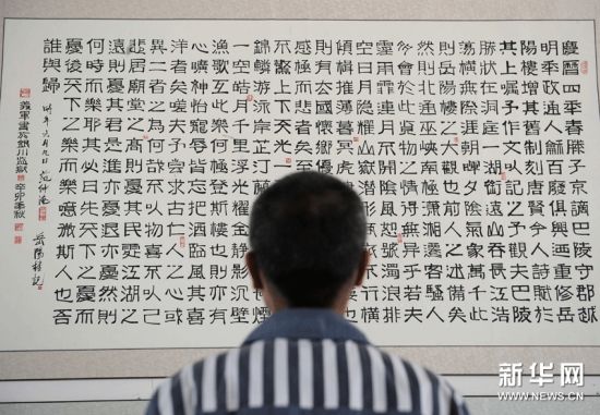 一名服刑人员在观看由服刑人员创作的书法作品