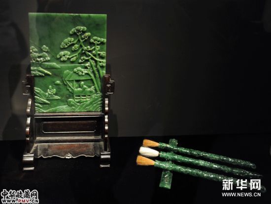 这是11月29日在台北历史博物馆拍摄的碧玉清秋高任图插屏（左）和翠玉龙纹组笔及镇尺。