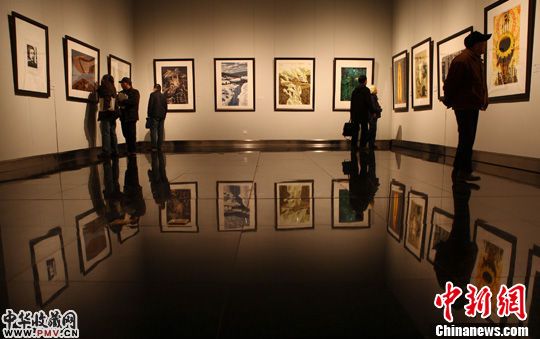 12月16日，观众正在欣赏展出的版画作品。