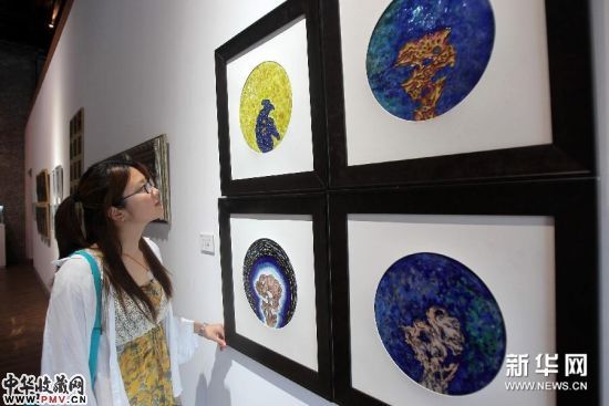 6月26日,在中国当代金属艺术展上,一名游客参观用铜和珐琅制作的作品《太湖石・印象》