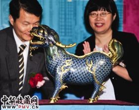 台北孙中山纪念馆馆长王福林(左)与台湾顽石创意公司工作人员共同展示“铜胎掐丝珐琅麒麟”。1860年从圆明园掠夺、现被法国枫丹白露宫收藏的“铜胎掐丝珐琅麒麟”与本展品本是一对