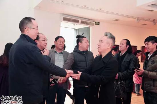 展览现场 艺术家曲比哈布与嘉宾亲切握手.webp