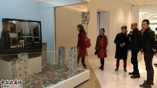 张湘溪（戴帽者）带嘉宾们看他的作品 张湘溪，四世同堂，电视机装置，尺寸可变，2009