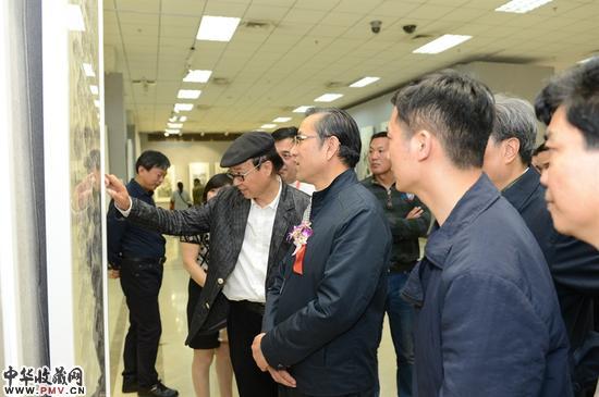 领导、专家认真观看画家作品