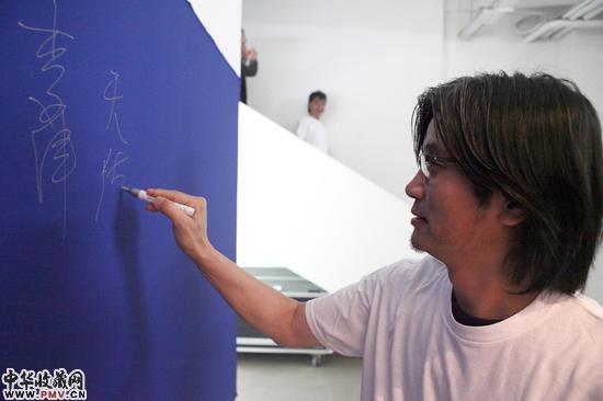参展艺术家王天德在签到墙签名