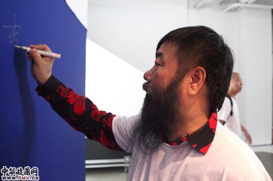 参展艺术家李津在签到墙签名