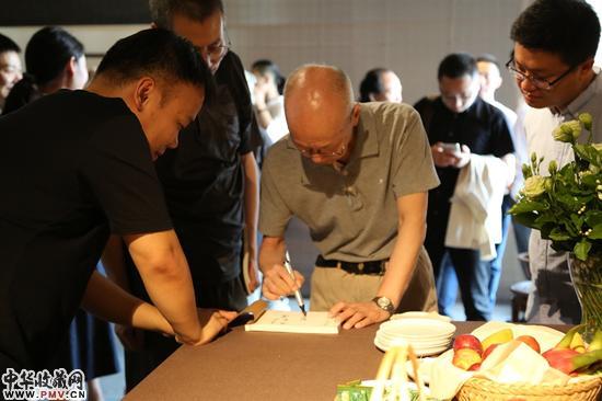 展览现场郎绍君为粉丝签名《砚田秋耕》作品集