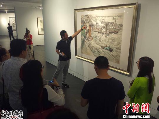山东美术馆策展人张膑向参观者介绍画作。齐鲁　胡健 摄